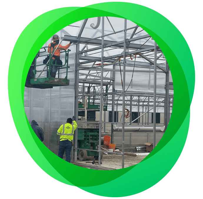 Construction crew assembling the outside of a Hydronov greenhouse facility.