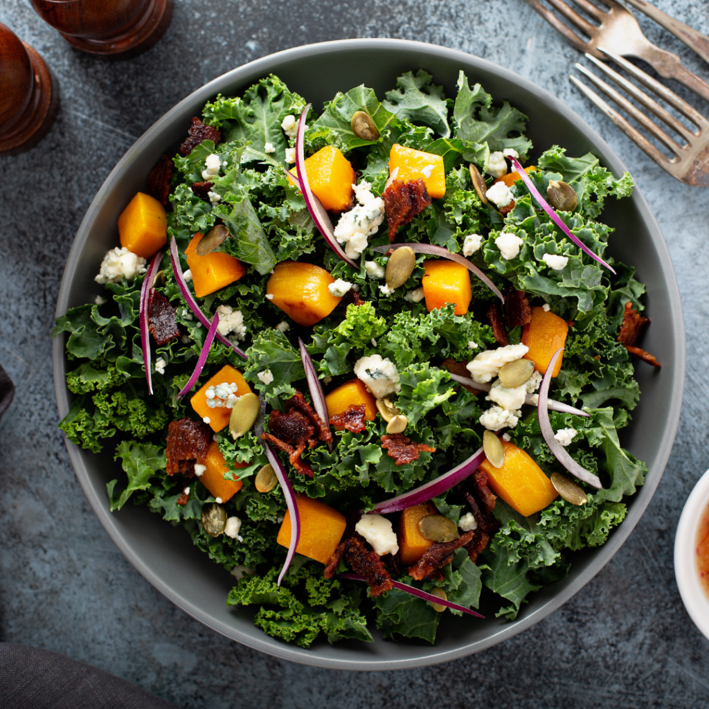 top-view of bowl of kale salad with sweet potato, onion, and cheese.